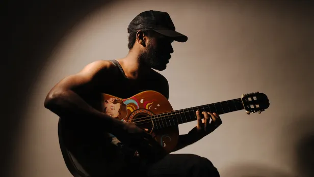 Motorcycle riding on a dirt road winding through a rocky desert canyon landscape.