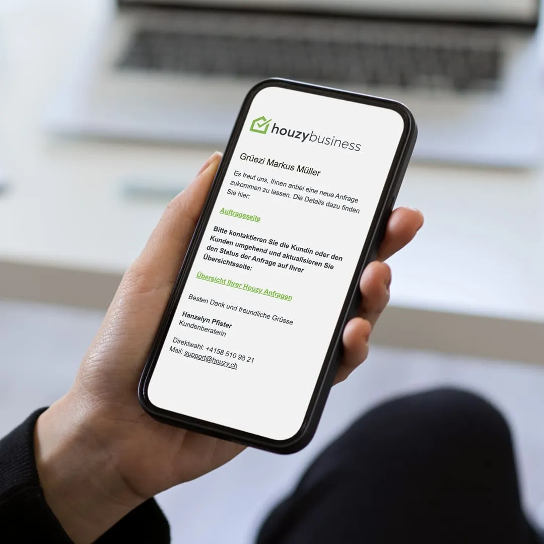 Ein Handwerker hält ein Smartphone mit einer neuen Kundenanfrage von Houzy. Das Bild zeigt den digitalen Prozess, um Handwerker-Aufträge und Anfragen von Kunden zu erhalten.