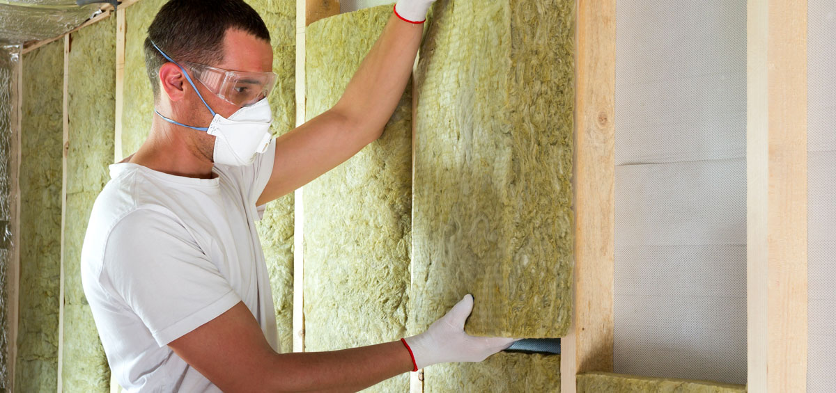 Kosten Fassade isolieren: Handwerker dämmt Hausfassade