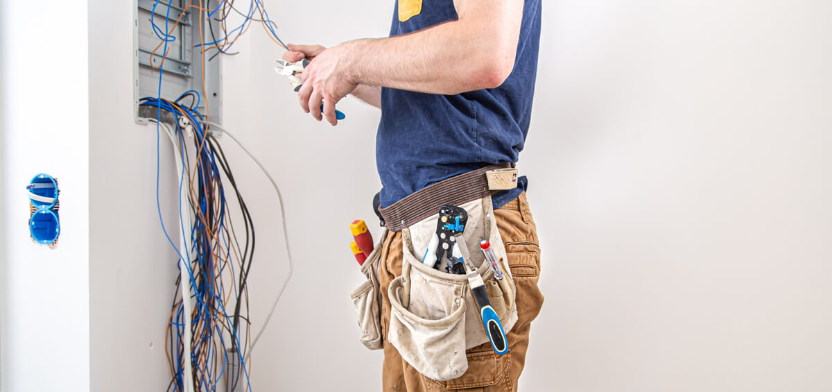 Kosten Elektriker: Ein Elektriker am Sicherungskasten