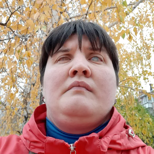 Anastasia standing surrounded by trees