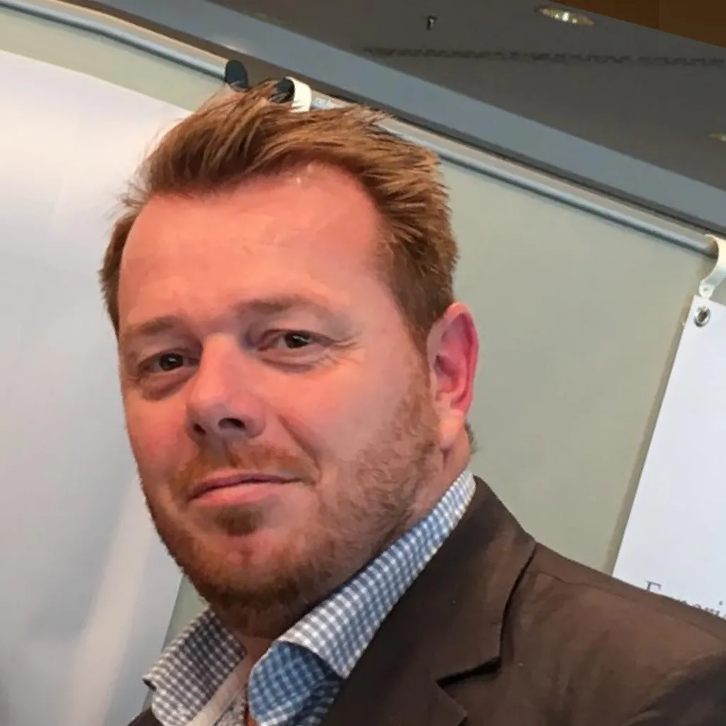 A picture of Pierre in a suit looking into the camera