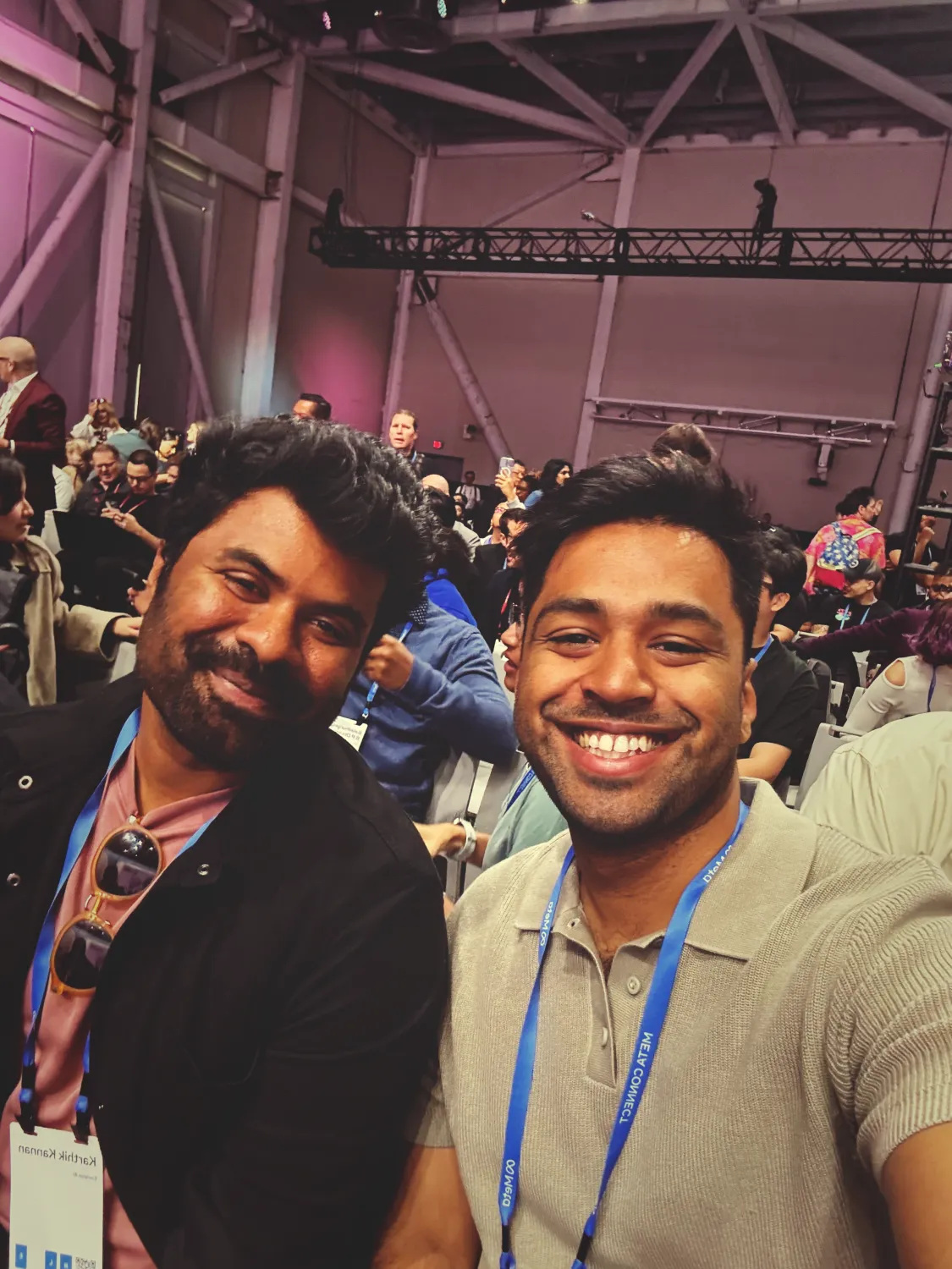 Karthik Mahadevan & I sitting in an audience at the very front row of the Connect keynote. We're wearing blue Connect lanyards.