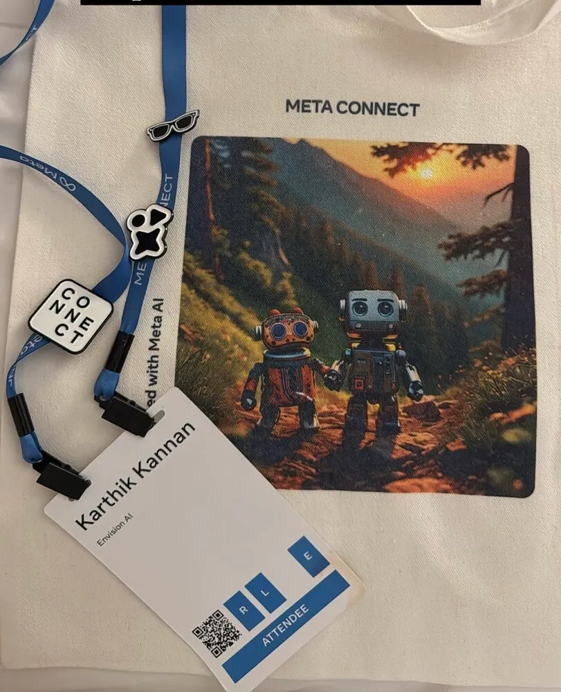 Alt: A Meta Connect event badge and lanyard for Karthik Kannan from Envision AI, along with event pins and a card featuring two cartoon robots in a scenic forest setting at sunset.