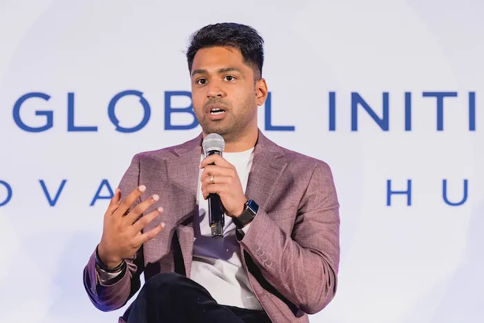 The CEO of Envision is holding a microphone and speaking during the Clinton Global Initiative