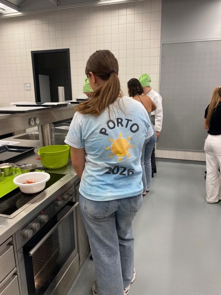 Porto 2026 Aufschrift auf T-Shirt einer jungen Frau in einer Küche