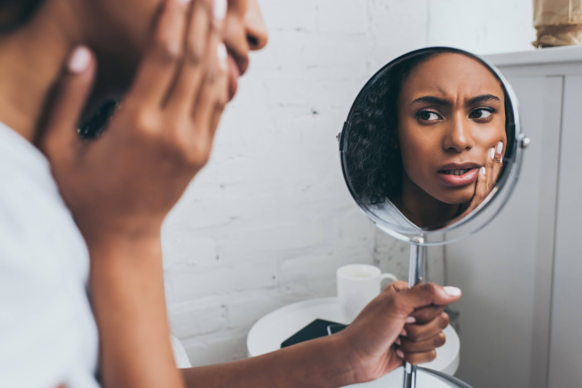 Woman looking in the mirror and recovering from All-on-4 in Marco Island 