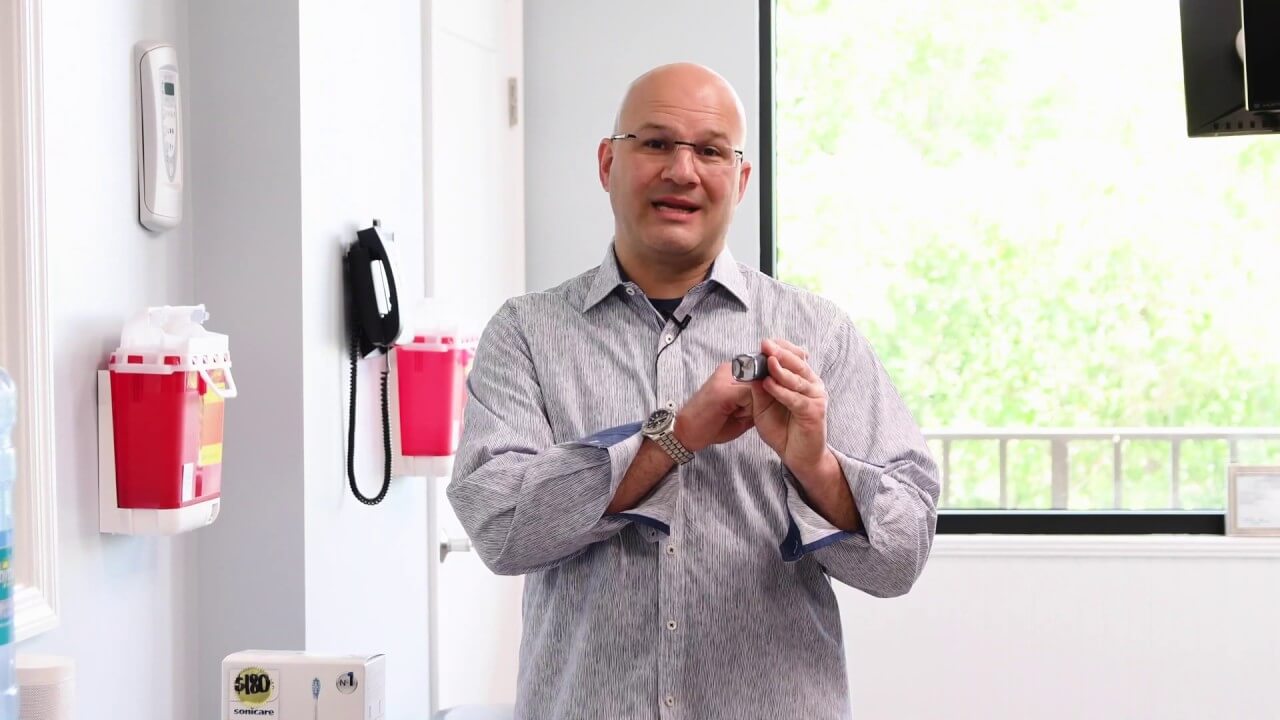 Dr. Abbiati holds a Phillips Sonic Care Toothbrush while describing it's benefits