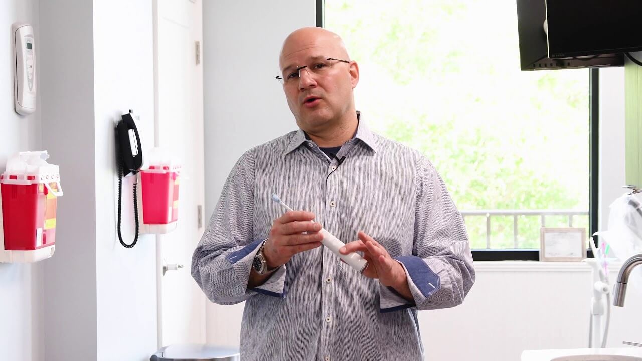 Dr. Abbiati holds both a manual and electric toothbrush