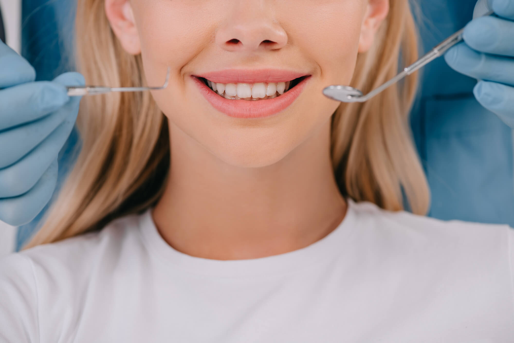 Patient smiling with a dentist behind her after a smile makeover in Marco Island