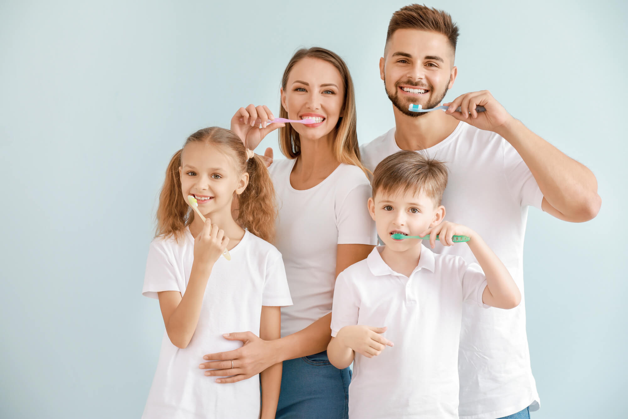 Family of four brushing their teeth before getting Family Dentistry services in Marco Island