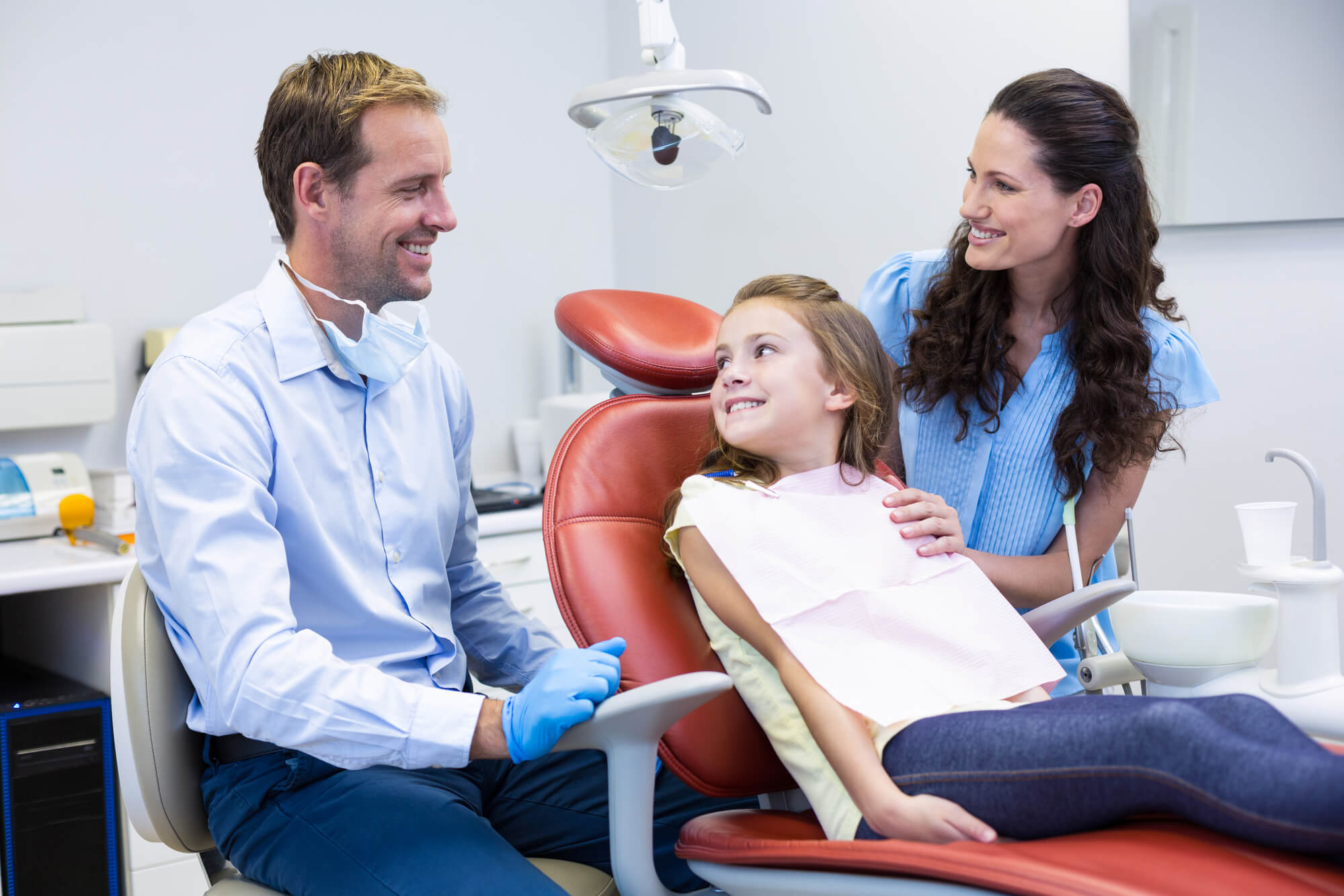 Little girl and her mother with a dentist getting Family Dentistry services in Marco Island