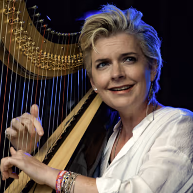 A woman with blonde hair playing a harp.