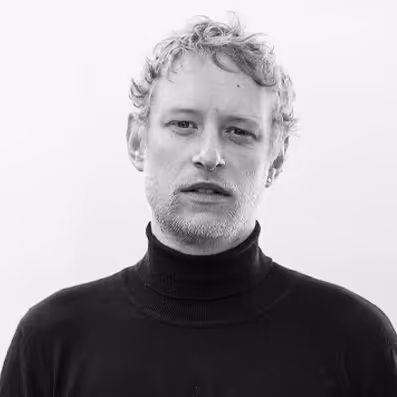 A black and white photo of a man in a turtle neck sweater.