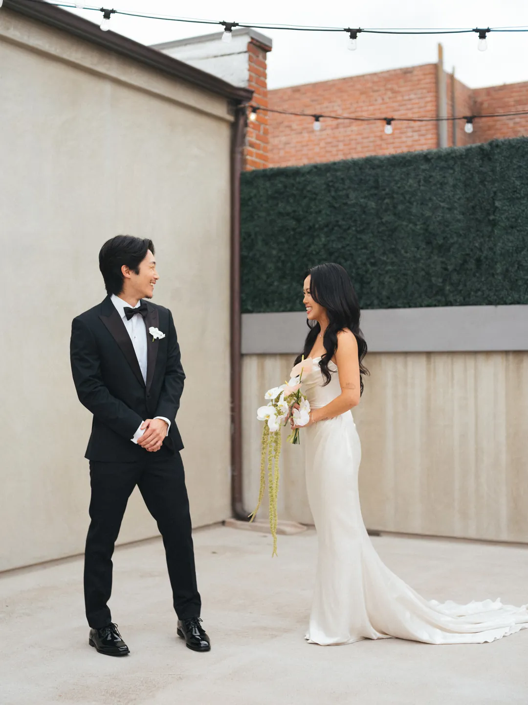 Groom standing across from the bride on an outdoor terrace