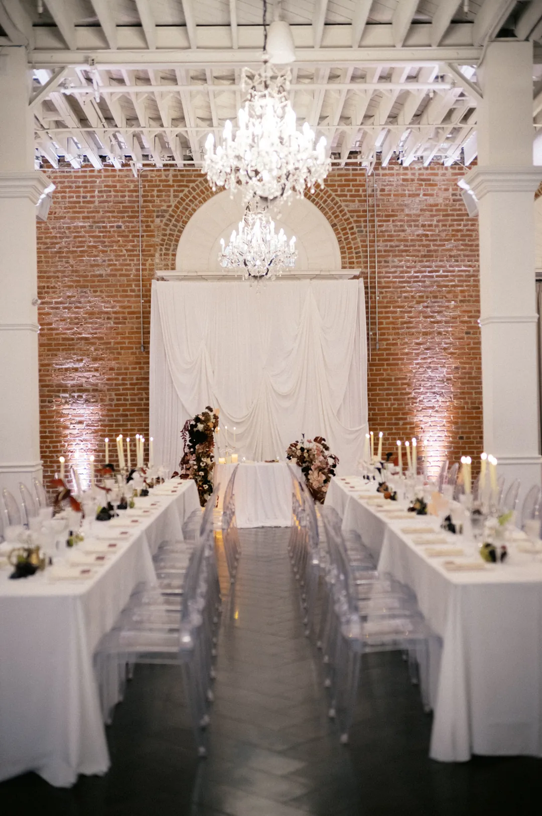 Long reception tables beneath an arched window