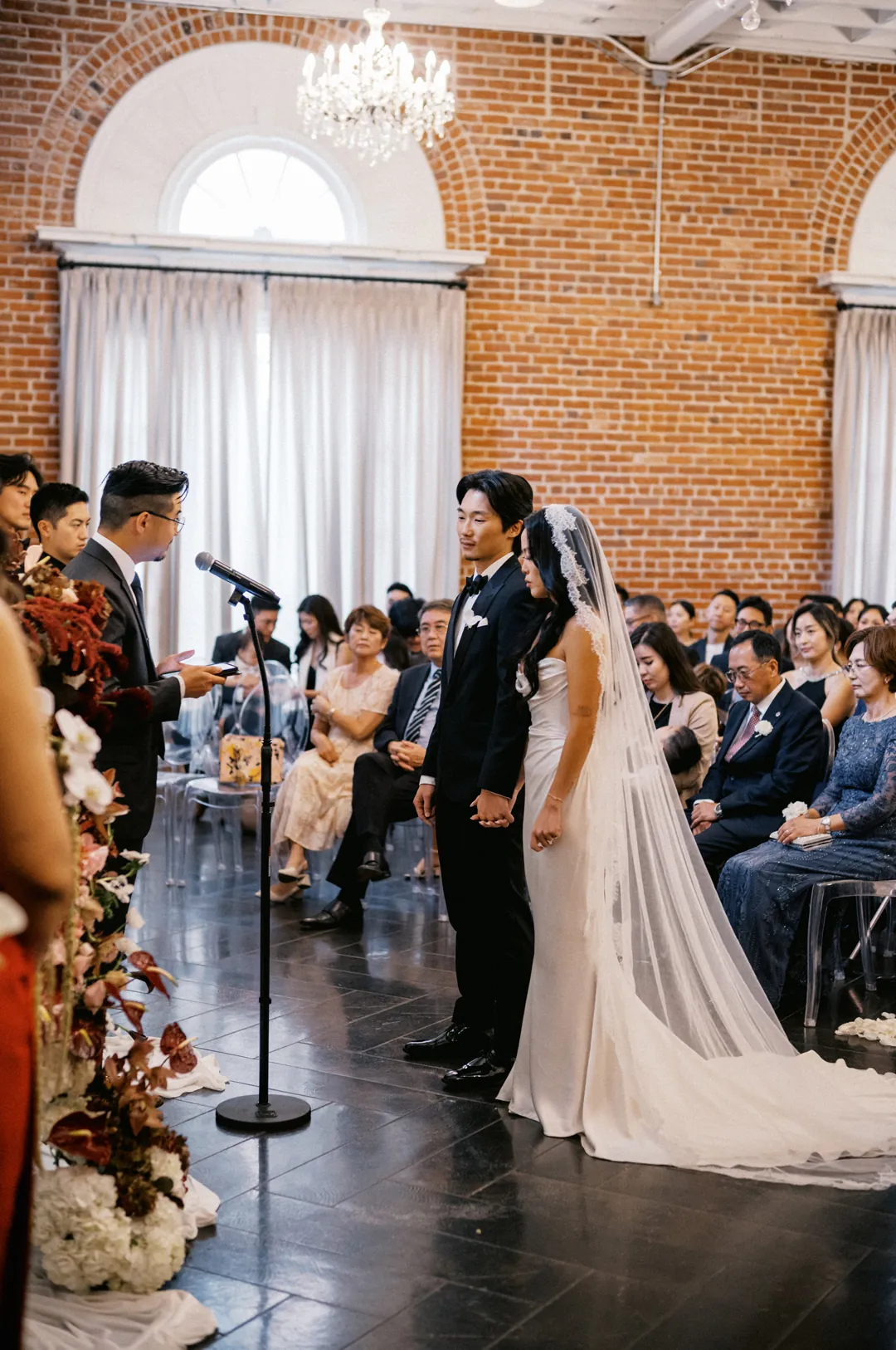 Couple exchanging vows before seated guests