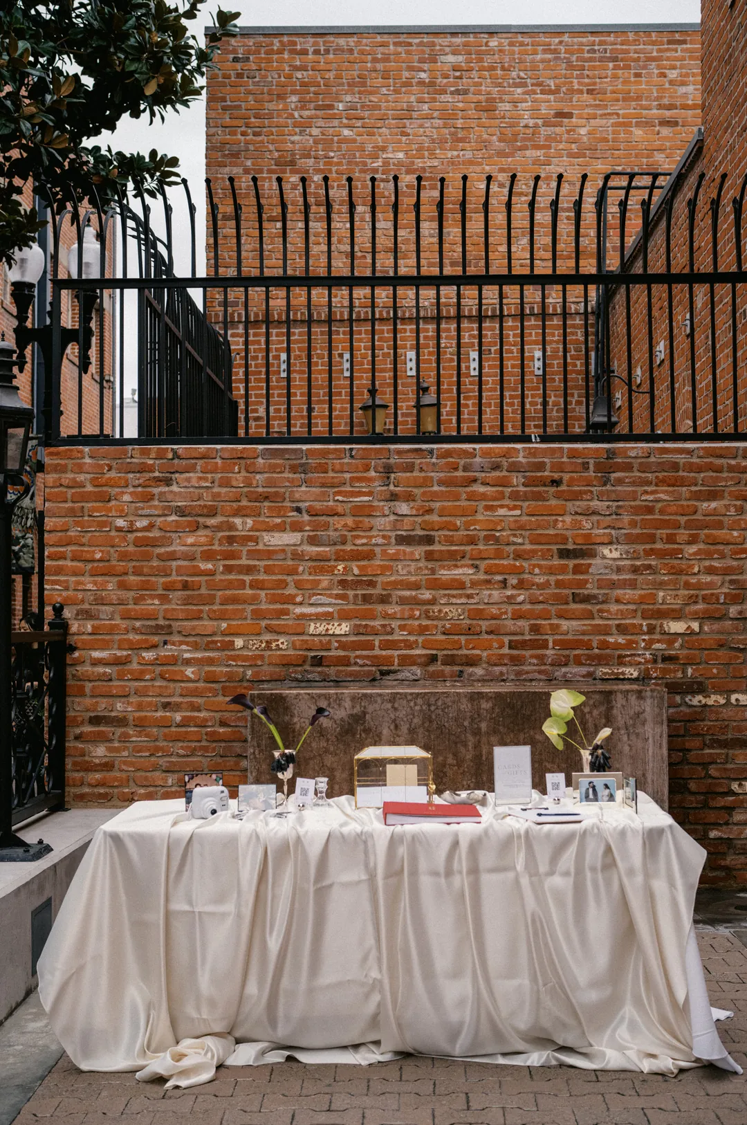 Outdoor sweetheart table beneath an iron railing