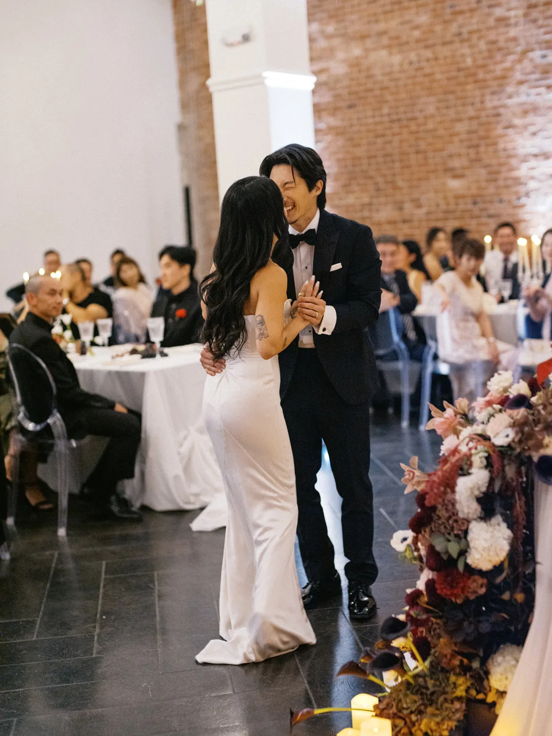 Couple dancing before seated reception guests