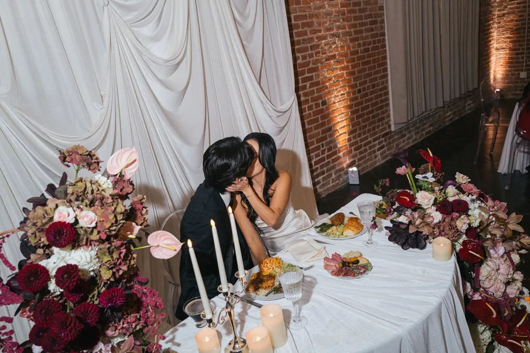 Couple kissing at their sweetheart table