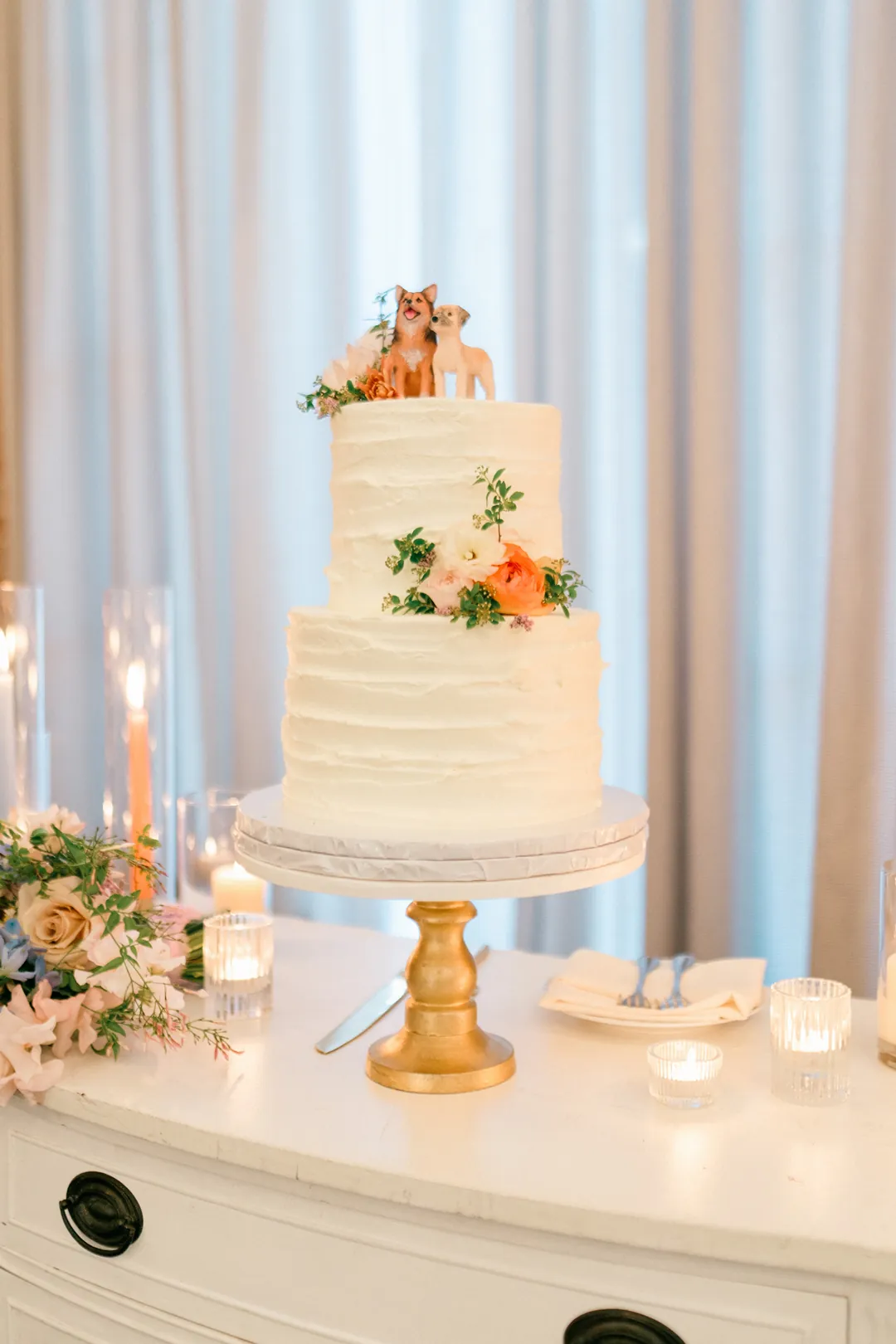 White tiered wedding cake decorated with orange flowers