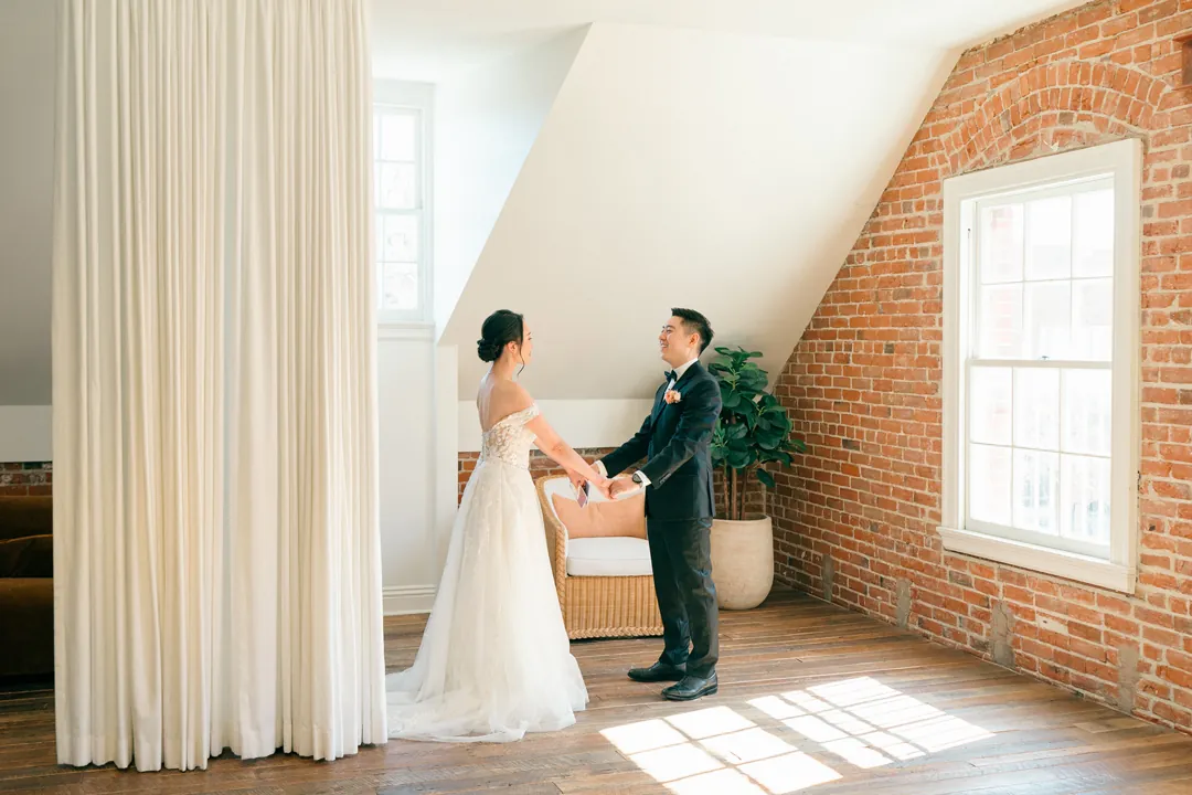 Couple holding hands in a sunlit loft