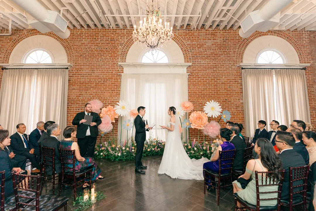 Couple exchanging vows before seated wedding guests