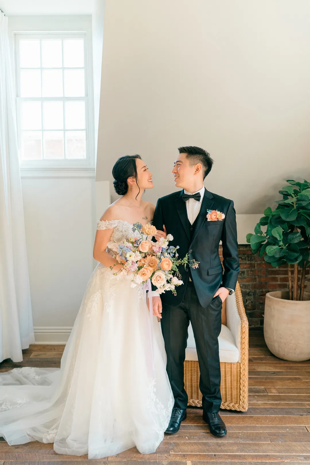 Couple posing together with a bouquet in a loft