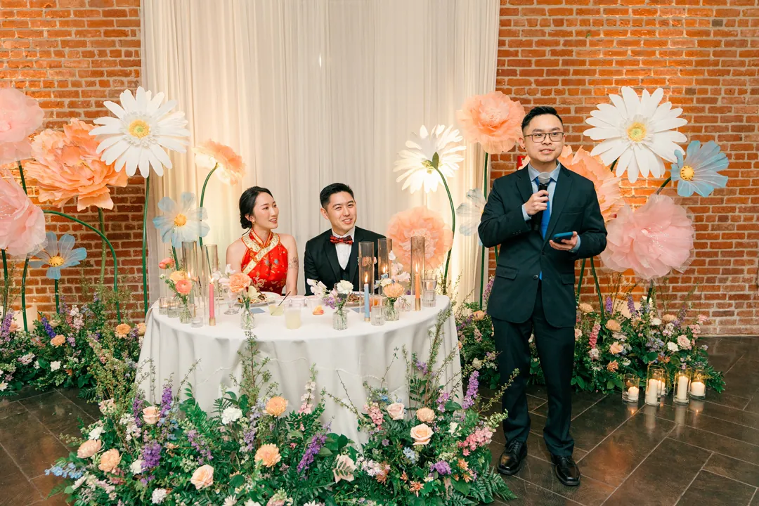 Guest giving a speech beside the seated couple