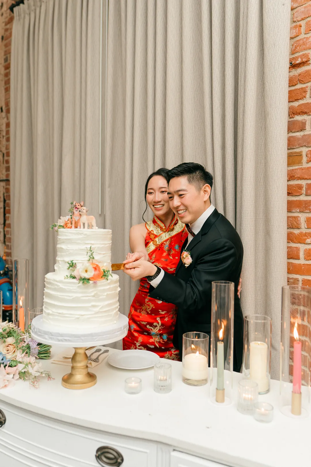 Couple posing beside their wedding cake