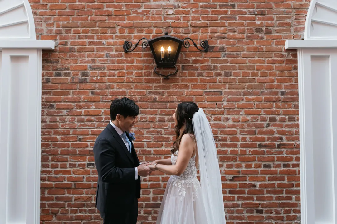 Couple facing each other outside a brick building