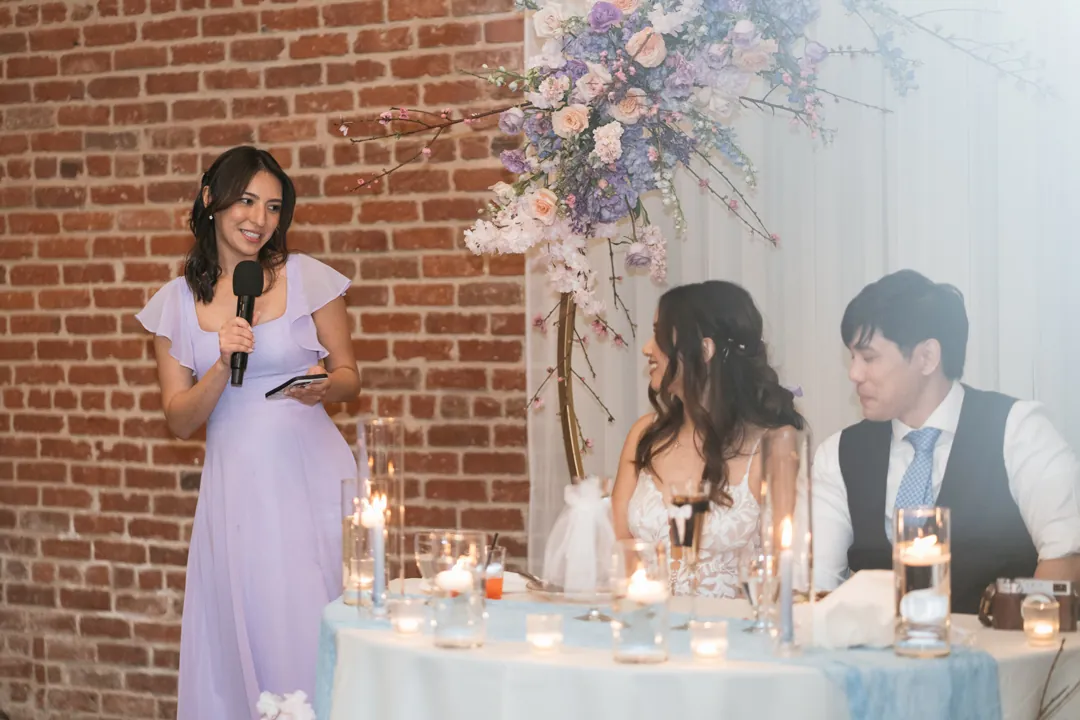 Guest giving a speech beside the seated couple