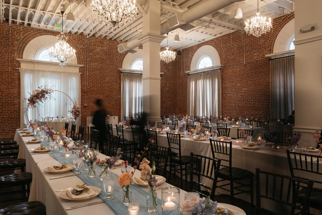 Reception tables beneath ballroom chandeliers