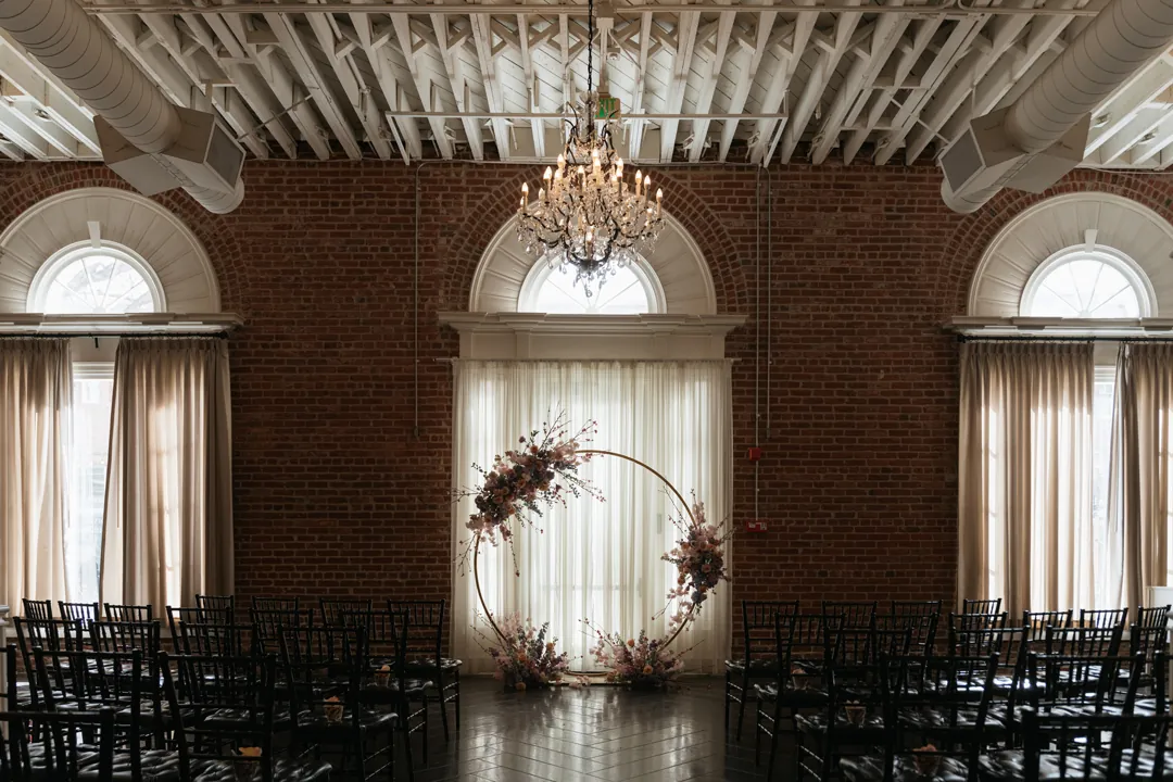 Empty ceremony aisle leading to a circular floral arch