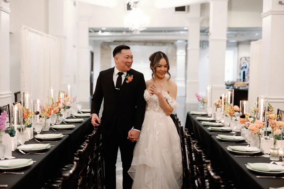 Couple walking between long reception tables