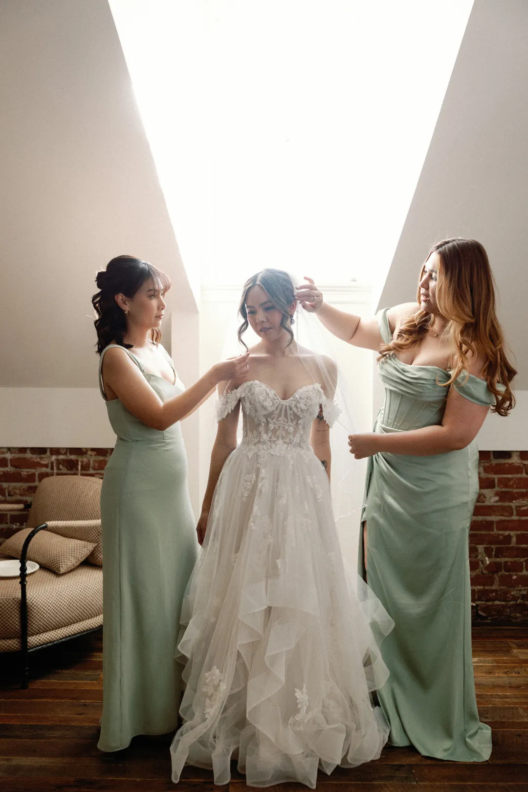 Attendants helping a bride get ready in a loft