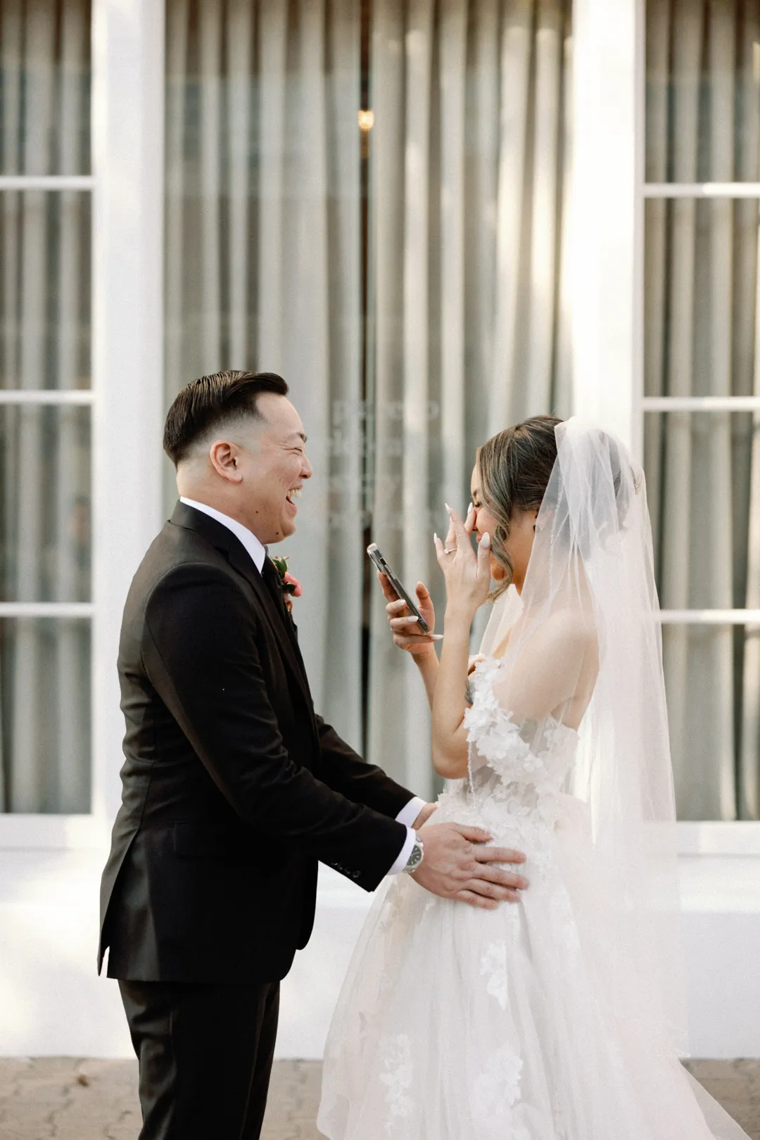 Couple embracing beside a tall window