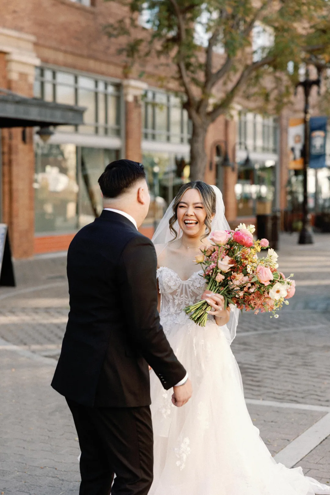 Couple smiling at each other on a sunny street