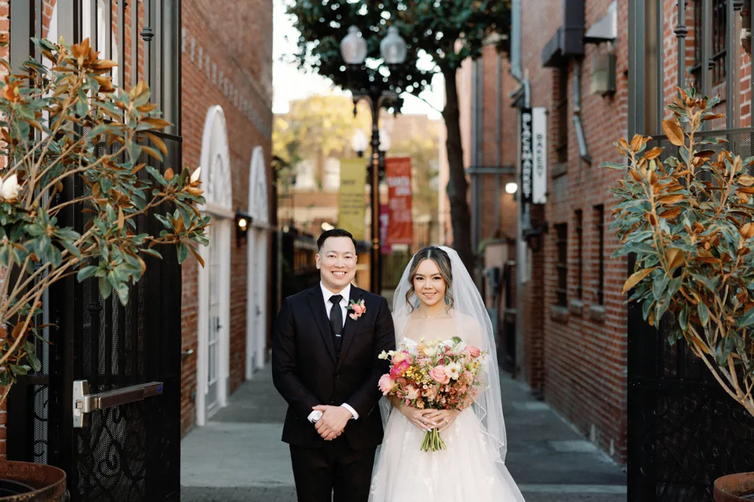 Couple standing together beside an iron gate