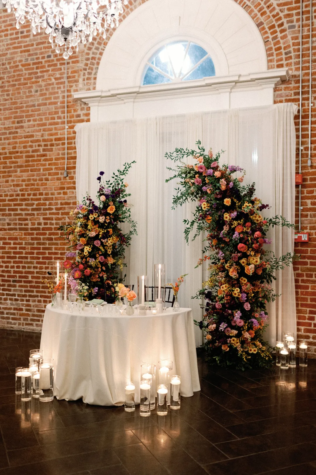 Sweetheart table beside a colorful floral arrangement