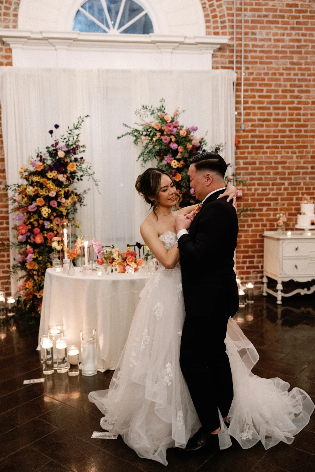 Couple dancing in front of their sweetheart table