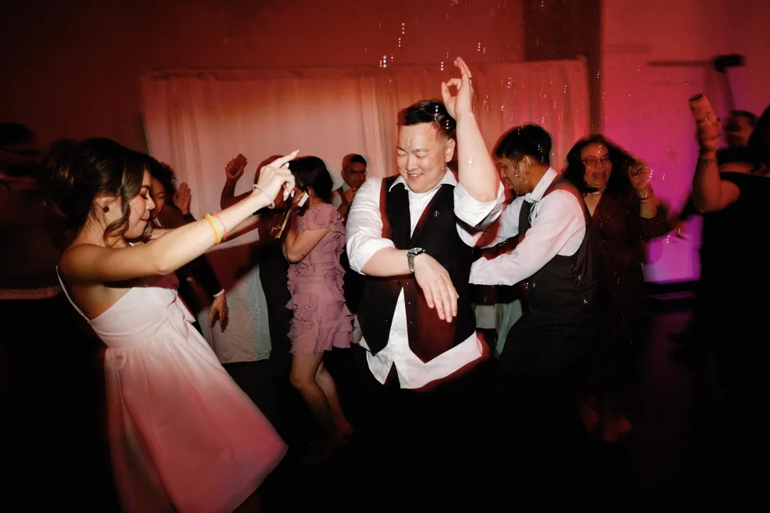 Groom and wedding guests cheering on the dance floor