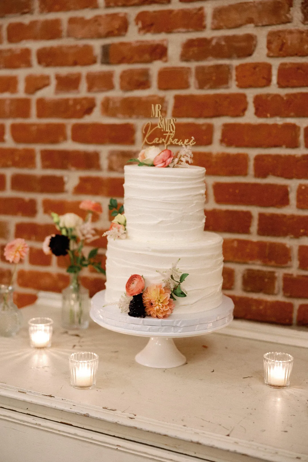 White wedding cake decorated with orange flowers