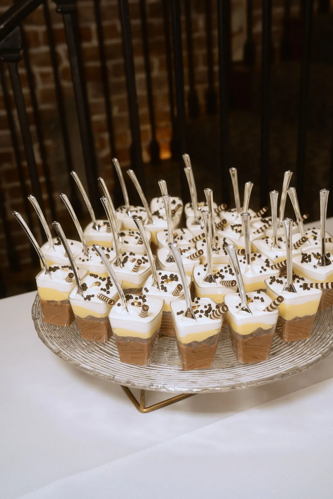 Small desserts on cocktail sticks displayed on a stand