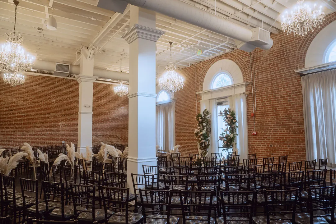 Rows of ceremony chairs in a brick ballroom