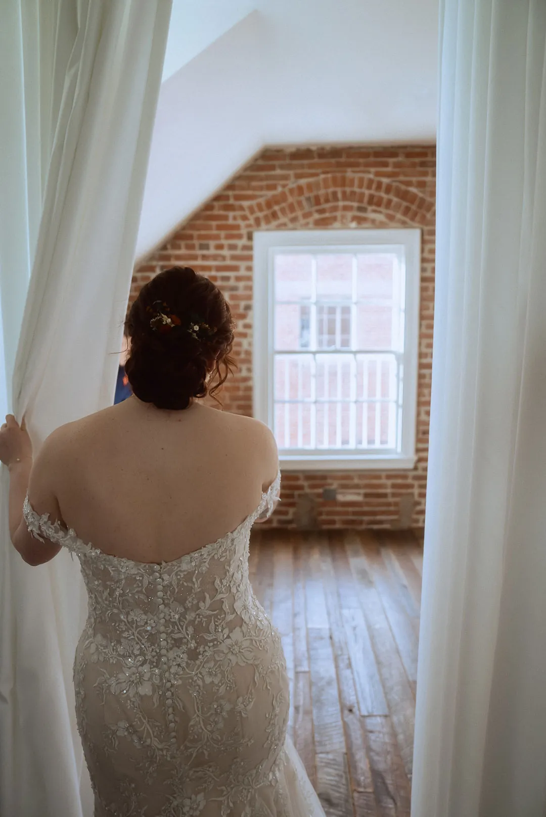 Bride looking out a loft window