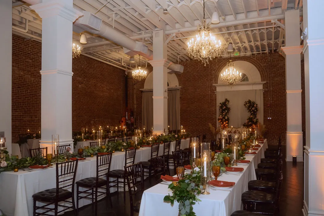 Long reception tables decorated with greenery and candles