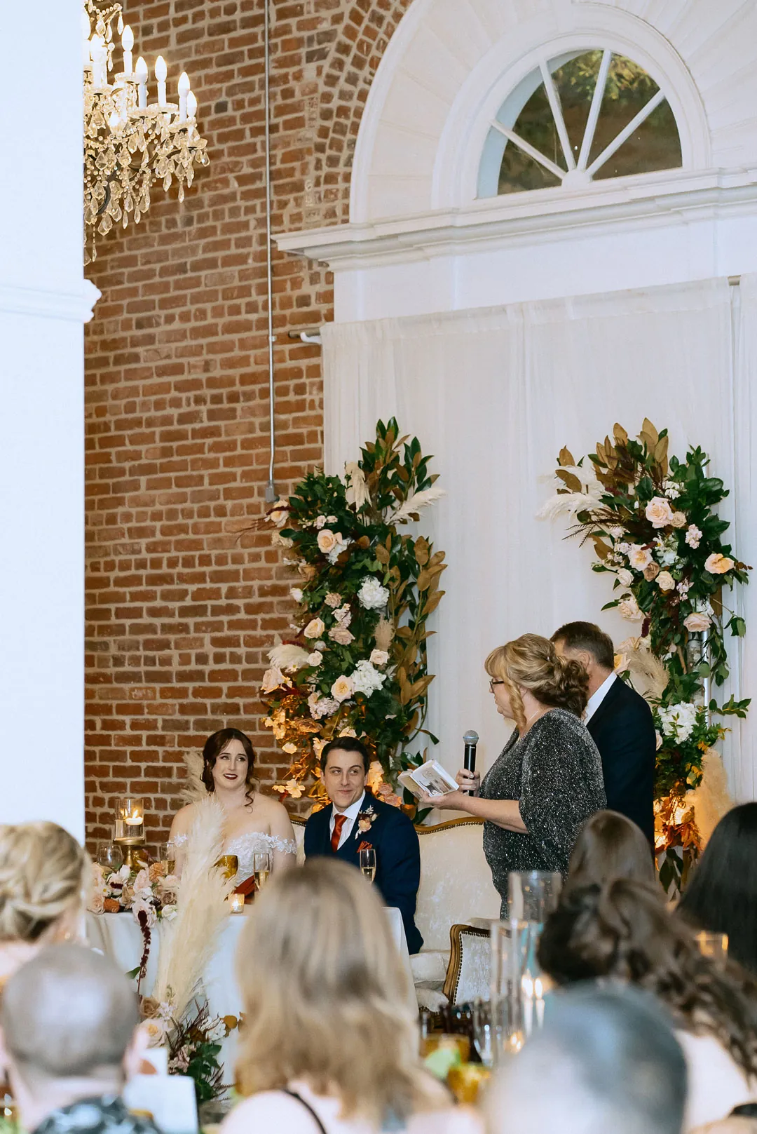 Guest giving a speech beside the couple's sweetheart table