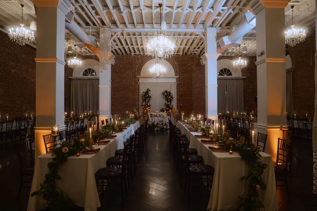 Candlelit reception tables beneath chandeliers