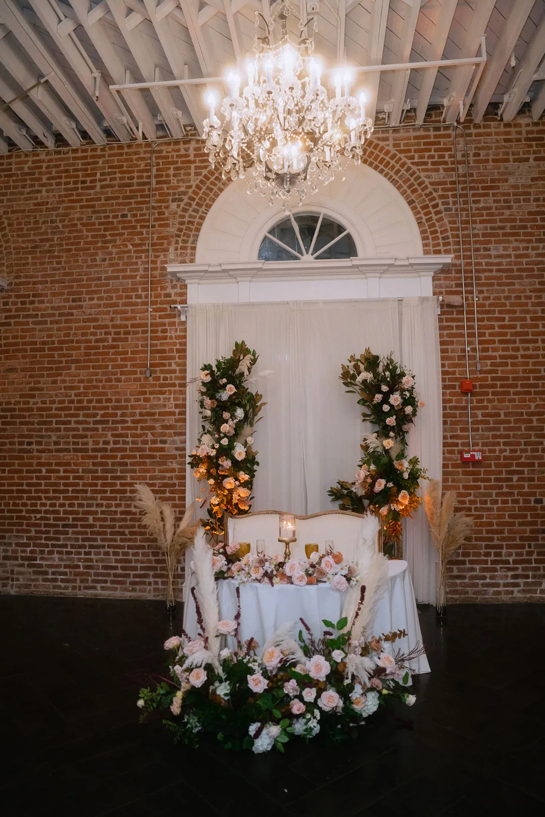 Sweetheart table beneath an arched window